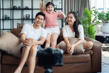 Asyalı mutlu aile sahnesi. Evde dijital kamerayla fotoğraf çektirirken, covid 19 salgınından kendini soyutlama sırasında..