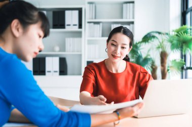 Asyalı iş kadınlarının seçici odak noktası projenin sunum ve çözüm planı hakkında stajyer ofis çalışanı, ofis yaşam tarzı, eğitim eğitimi, insan kaynakları.