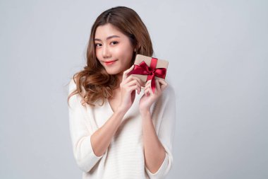 Mutlu bir şekilde gülümseyen genç bir kadının portresi ve bayram, yeni yıl kutlaması ya da noel arifesi için hediye olarak sunulan bir konsept sunan hediye kutusu..