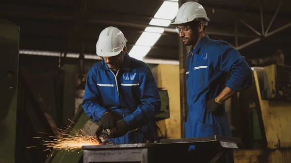 Scene shot of industrial workers concentrates on metal grinding together, training for professional operation, the procession of the manufacturer, safety manufacturer, training and workshop worker.