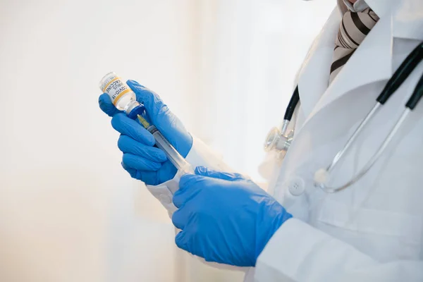 針注射器を使用しながら青い手袋を保持Covidワクチンボトルを身に着けている患者のための準備 — ストック写真