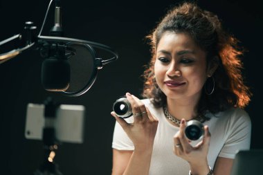 Ürün tavsiyesi için podcaster resmi. İnternet üzerinden alışveriş yaparken kamerayla konuşan blogcuyu incele. Çevrimiçi öğrenme ya da sosyal pazarlama kavramını. Canlı podcast ve ağ reklamları.