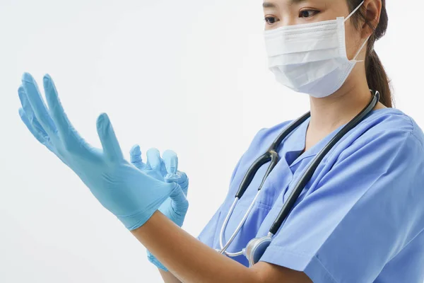 コピースペースで白い背景に手袋をしながら保護マスクを身に着けているアジアの女性医師や看護師を閉じます 病院における医療の概念 — ストック写真