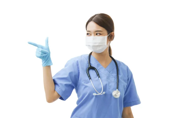 若いですアジアの女性で看護師制服で聴診器を着用し 彼女の指を左画面にコピースペースを持っています 隔離された白い背景に概念看護師発表者 — ストック写真