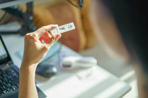 SARS 2019-NCoV COVID-19 antijen hızlı test kiti tutan insanların arkasından çekilen görüntüler olumlu sonuç veriyor. ATK ilk yardım için evde ya da ofiste hızlı bir test yapar..