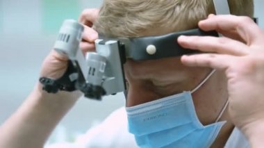 diş hekimi maskeli ve alın el feneri ile