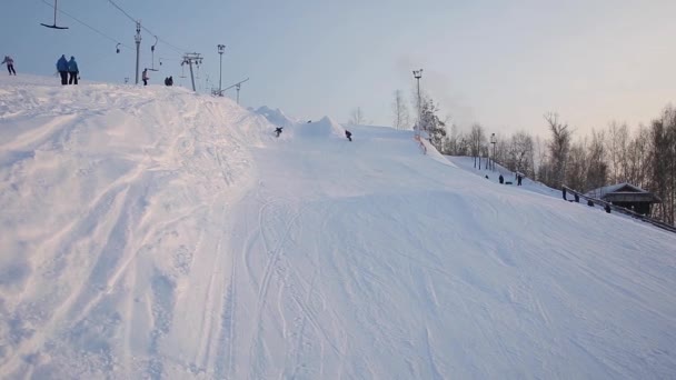 Snowboardåkare utföra trick på sluttningarna — Stockvideo