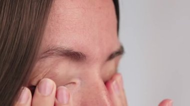 Elleriyle gözlerini ovuşturan bir kadının yakın çekimi, yorgunluk, aşırı çalışma, kuraklık veya alerji konsepti..