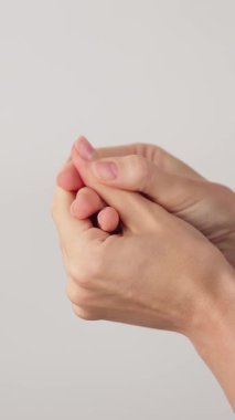 Zarif manikürlü, birbirine nazikçe masaj yapan kadın ellerinin dikey yakın çekimi. Rahatlama, özgüven ve güzellik. Güzellik Salonu. Boşluğu kopyala