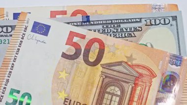 Avro ve ABD dolar banknotları sırasıyla para değişimi, nakit dolaşımı, para dolaşımı, ön x ticaret, finans piyasası ve nakit akışı kavramlarını gösteren bir masaya düşer..