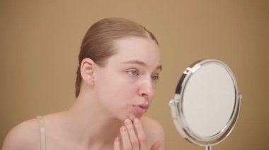Endişeli Genç Kadın Z Dokunaklı Yanak, Aynadaki Deriyi İnceleme. Sivilceler, Cilt Sorunu Farkındalığı, Kişisel Bakım Rutini. Sivilce Tedavisi