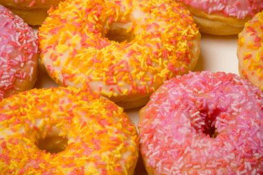 Beyaz bir arkaplanda buzlu halka donutları