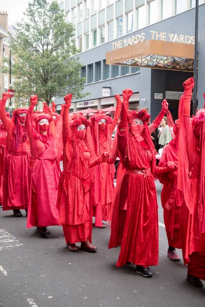 ロンドン イギリス 2021年8月21日 ロンドン中央部を行進する赤い服を着た絶滅の反乱抗議者 — ストック写真