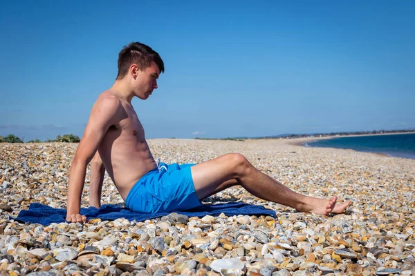 Teenage boy sitting beach looking hi-res stock photography and images -  Alamy