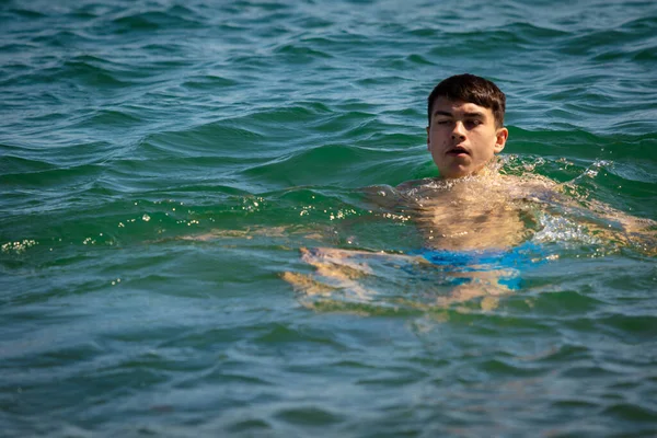 一名18岁的白种人少年穿着泳衣在海里悠闲自在 — 图库照片