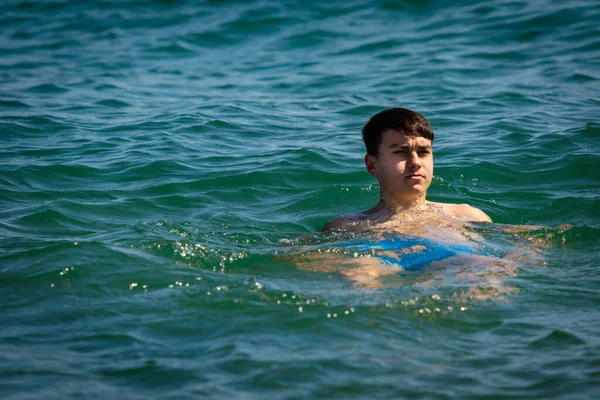 一名18岁的白种人少年穿着泳衣在海里悠闲自在 — 图库照片