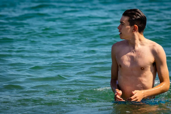 海の中に立つ水着姿の18歳の白人男の子 — ストック写真