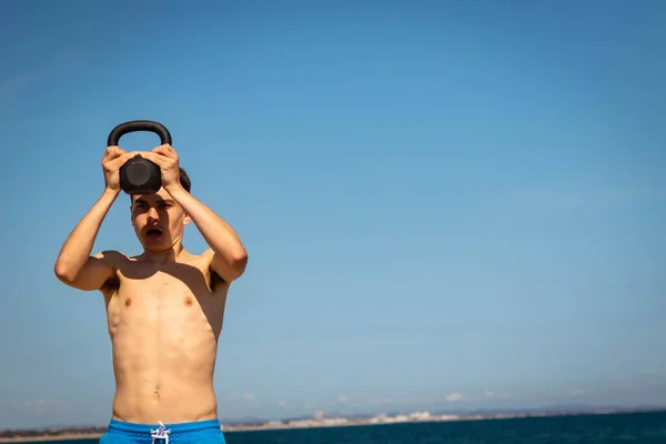 Letý Běloch Bez Košile Dospívající Chlapec Pláži Cvičení Kettlebell Hmotnost — Stock fotografie