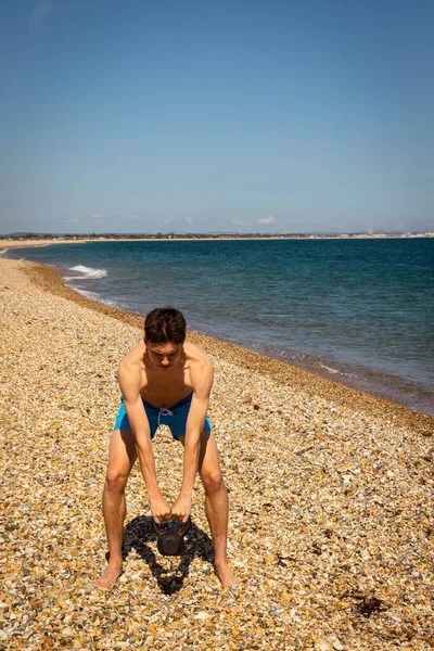 Egy Éves Kaukázusi Félmeztelen Tinédzser Fiú Tengerparton Aki Kettlebell Súllyal — Stock Fotó