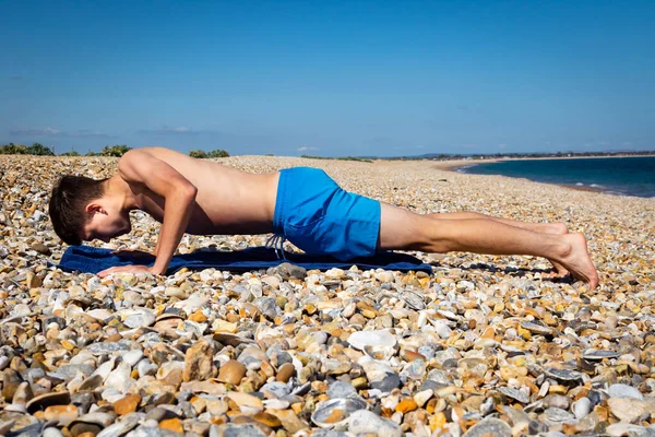 Letni Biały Nastolatek Robi Prasę Kamienistej Plaży — Zdjęcie stockowe