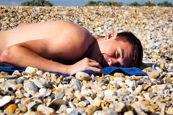 一名18岁的白人少年在石滩上做完俯卧撑后躺了下来 — 图库照片