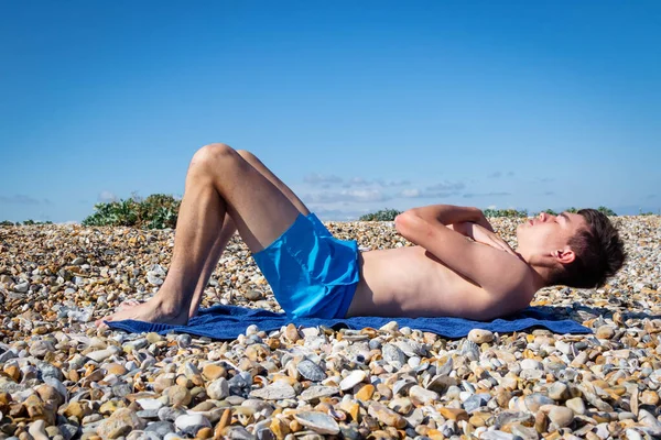 Letni Biały Nastolatek Bez Koszuli Robi Siady Kamienistej Plaży — Zdjęcie stockowe