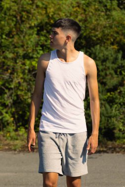 18 yaşında kolsuz tişörtlü bir genç yaz günü