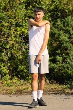 18 yaşında kolsuz tişörtlü bir genç yaz günü