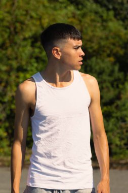 18 yaşında kolsuz tişörtlü bir genç yaz günü