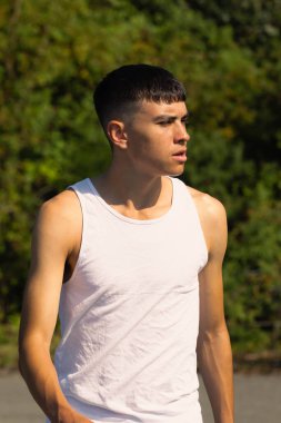 18 yaşında kolsuz tişörtlü bir genç yaz günü