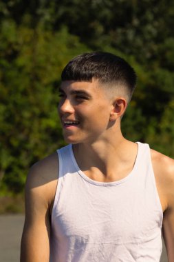18 yaşında kolsuz tişörtlü bir genç yaz günü