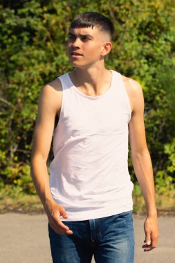 18 yaşında kolsuz tişörtlü bir genç yaz günü