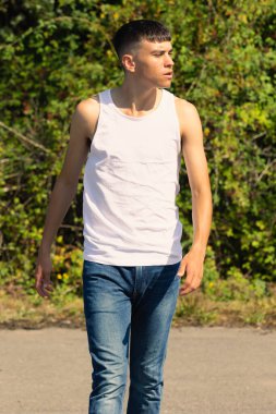 18 yaşında kolsuz tişörtlü bir genç yaz günü