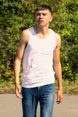 18 yaşında kolsuz tişörtlü bir genç yaz günü