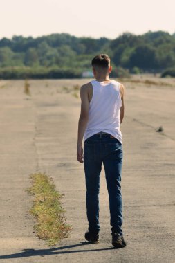 18 yaşında kolsuz tişörtlü bir genç yaz günü