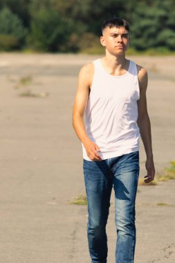 18 yaşında kolsuz tişörtlü bir genç yaz günü
