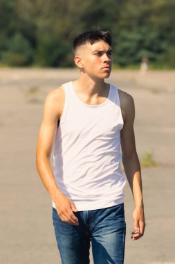 18 yaşında kolsuz tişörtlü bir genç yaz günü