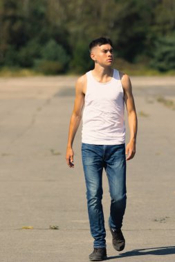 18 yaşında kolsuz tişörtlü bir genç yaz günü