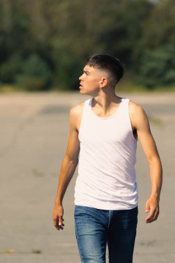 18 yaşında kolsuz tişörtlü bir genç yaz günü