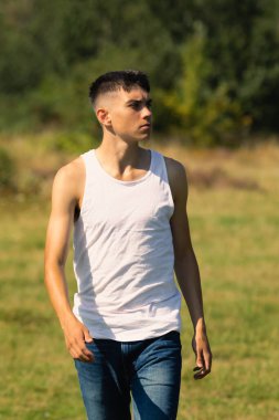 18 yaşında kolsuz tişörtlü bir genç yaz günü