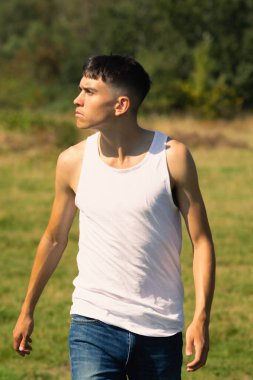 18 yaşında kolsuz tişörtlü bir genç yaz günü