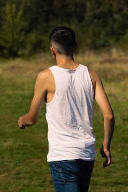18 yaşında kolsuz tişörtlü bir genç yaz günü