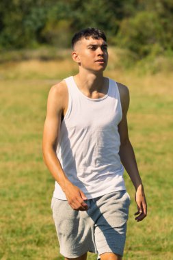 18 yaşında kolsuz tişörtlü bir genç yaz günü