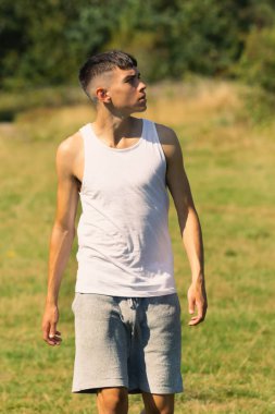 18 yaşında kolsuz tişörtlü bir genç yaz günü