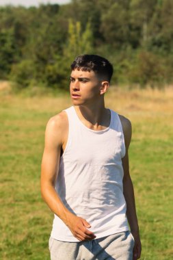 18 yaşında kolsuz tişörtlü bir genç yaz günü