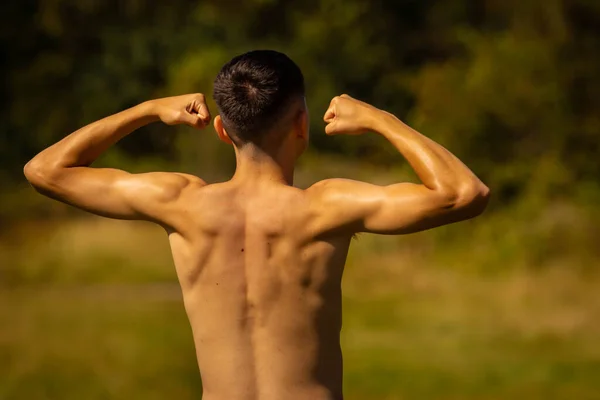 Adolescente Dezoito Anos Flexionando Músculos Dia Quente Verão Vestindo Shorts — Fotografia de Stock