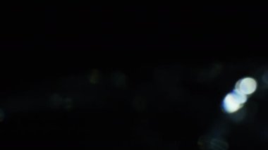 Karanlıkta 4k Soyut Kristal Bokeh. Düzenleme için arkaplanı üst üste koy. Parlak Işık Sızıntısı
