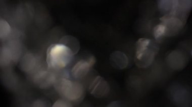 Karanlıkta 4k Soyut Kristal Bokeh. Düzenleme için arkaplanı üst üste koy. Parlak Işık Sızıntısı