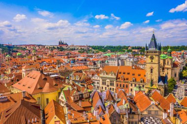 Drone image of Prague historic center showing red rooftops, gothic churches, narrow streets, baroque architecture and Vltava River winding through the Czech capital city