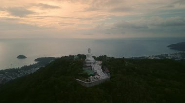 Phuket heykelinin büyük Buda heykeli sahil kenti havadan manzaralı tepenin üzerine dikilmiş. Sakin deniz suyuna karşı geleneksel Budist tanrı anıtı. Asya kültür tarihi gözlemleme